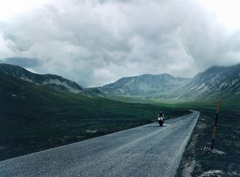 Rear view of people riding on mountain road