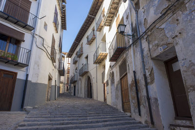 Low angle view of alley amidst buildings in city