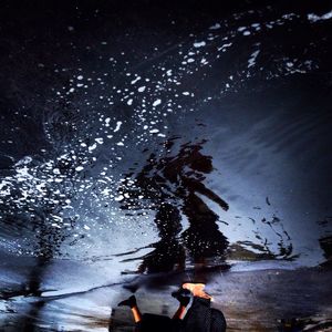 Low section of woman standing on puddle