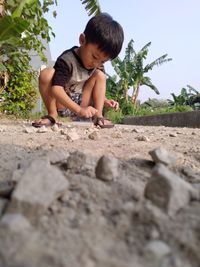 Full length of boy playing on footpath