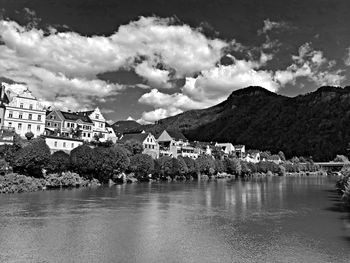 Scenic view of river by buildings against sky