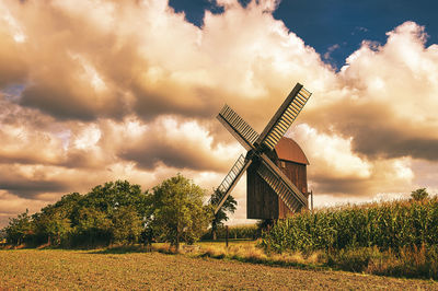 Traditional windmill on field against sky