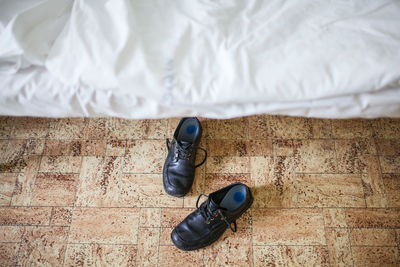 High angle view of shoes by bed on floor