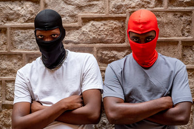 Two afro young men in ski masks in alleyway