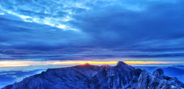 Scenic view of snowcapped mountains against dramatic sky