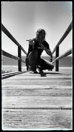 Woman jumping on pier