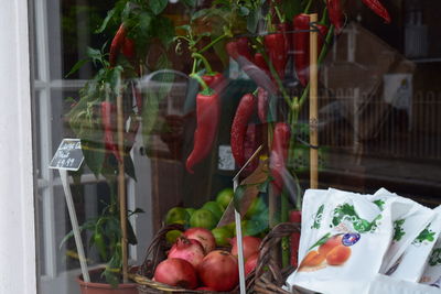 Pomegranates and tomatoes on retail display at store window