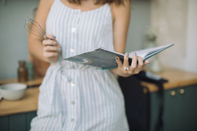 Midsection of woman reading book