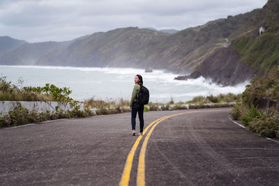 Rear view of man on road against mountain