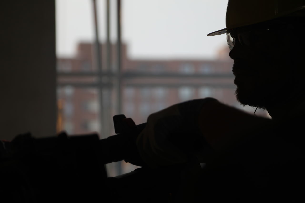 PORTRAIT OF SILHOUETTE MAN HOLDING WINDOW