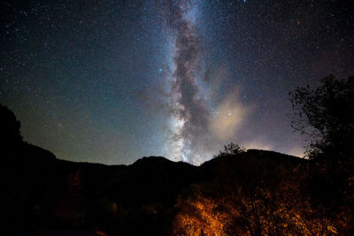 Scenic view of silhouette mountain against sky at night