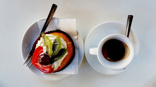 Directly above shot of coffee cup with dessert on white background