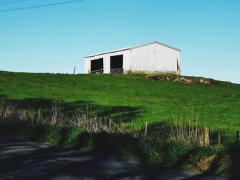 House on field against clear sky