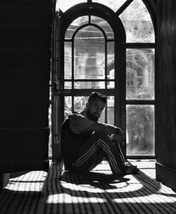 Man looking through window in building