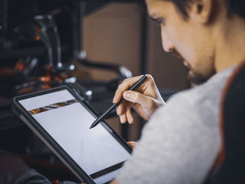 A caucasian guy holds a tablet and choosing a menu for online ordering food