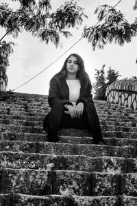 Portrait of young woman sitting on steps