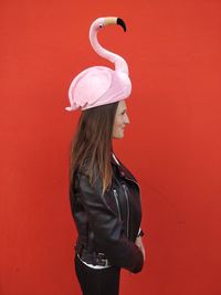 Woman standing against red wall