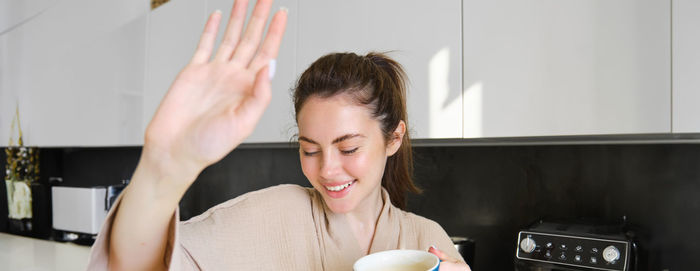 Portrait of young woman with hands with arms raised