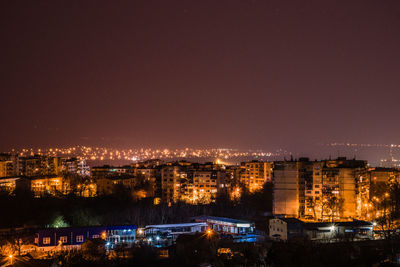 Illuminated cityscape against sky at night