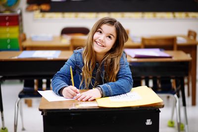 Portrait of a smiling young woman sitting on table