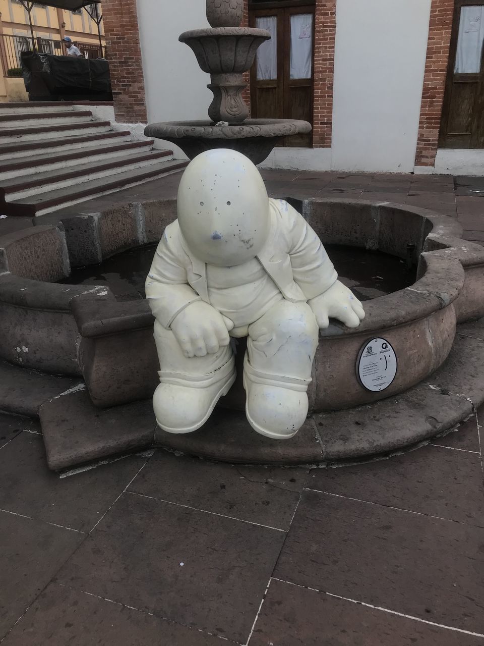 STATUE AGAINST WHITE BUILDING