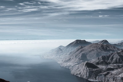 Scenic view of snowcapped mountains by sea against sky