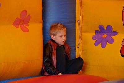 Boy sitting on colorful inflatable equipment