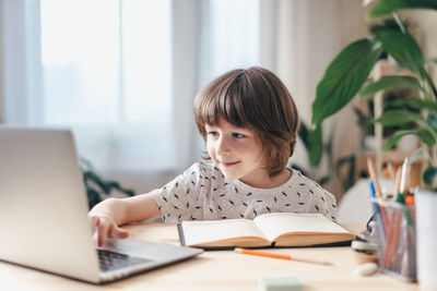 Portrait of boy sitting on table