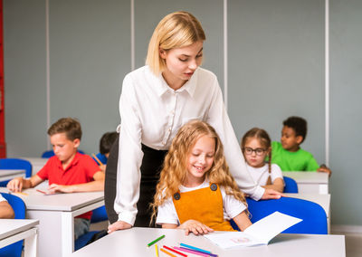 Teacher teaching student at classroom