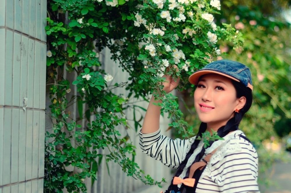 person, lifestyles, casual clothing, leisure activity, looking at camera, portrait, tree, growth, young adult, front view, smiling, plant, standing, focus on foreground, young women, waist up, day, three quarter length