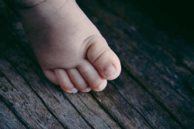 Close-up of baby hand on wood