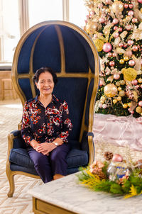 Portrait of woman sitting on sofa at home