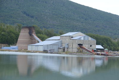 Buildings by lake against mountain