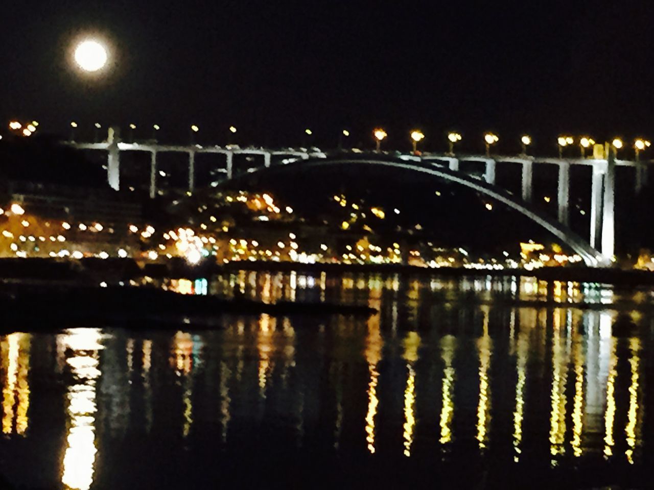 illuminated, night, water, reflection, built structure, architecture, bridge - man made structure, connection, river, street light, waterfront, lighting equipment, bridge, building exterior, city, transportation, clear sky, outdoors, dark, light - natural phenomenon