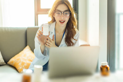 Portrait of young woman sitting on table