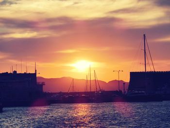 Sailboats in sea against sky during sunset