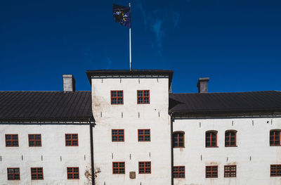 Low angle view of buildings against clear blue sky