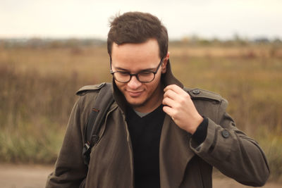 Stylish young man on autumn background. man feeling freeze and wrap up in a coat. fall fashion. 