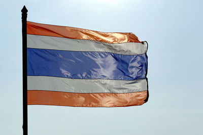 Low angle view of thai flag against clear blue sky