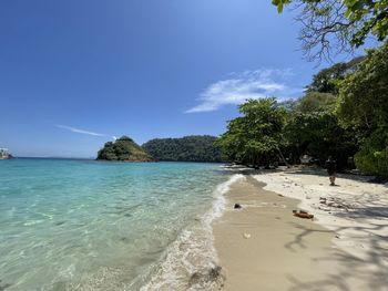 Scenic view of beach against clear blue sky