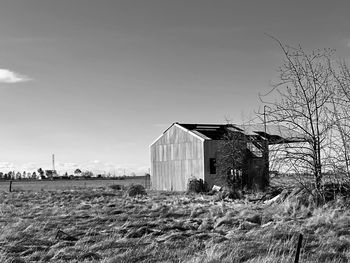 Abandoned building on field against clear sky