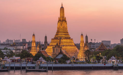 Buildings in city against sky during sunset