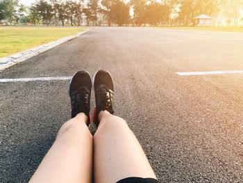 Low section of man relaxing on road