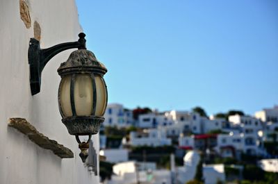 Close-up of street light on wall against sky