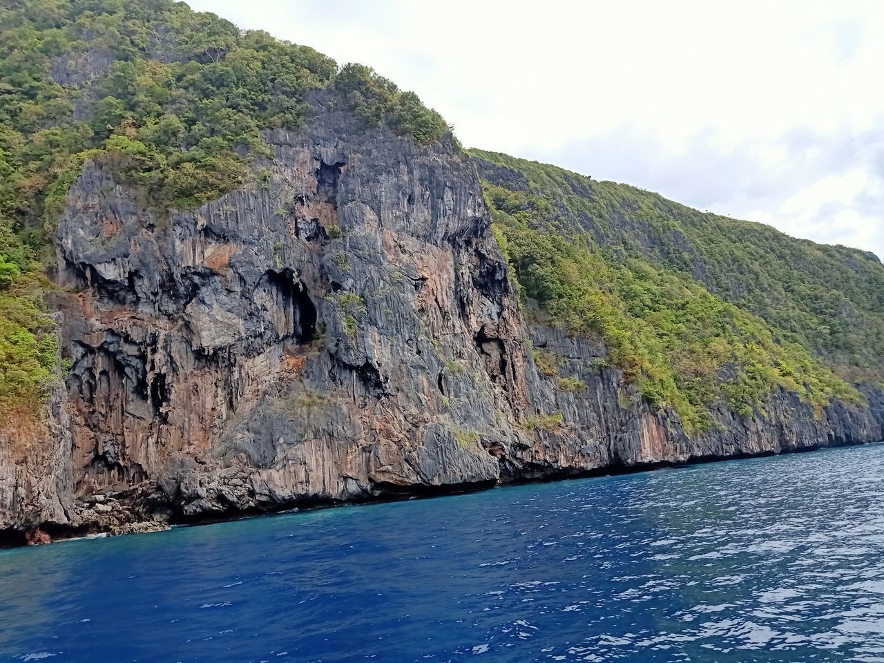 SCENIC VIEW OF SEA BY ROCK FORMATION AGAINST SKY