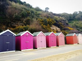 Beach huts by buildings against sky