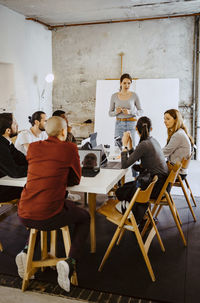 Male and female programmers discussing in meeting at creative office