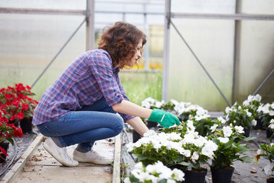 Smiling woman working in greenhouse