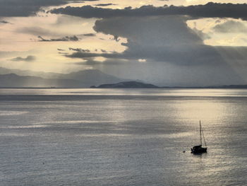 Sailboat sailing on sea against sky during sunset