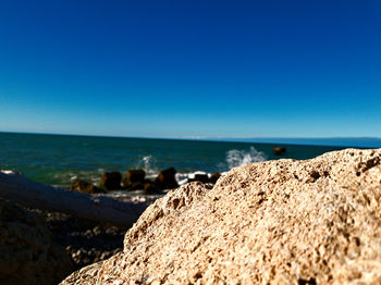 Scenic view of beach against clear blue sky